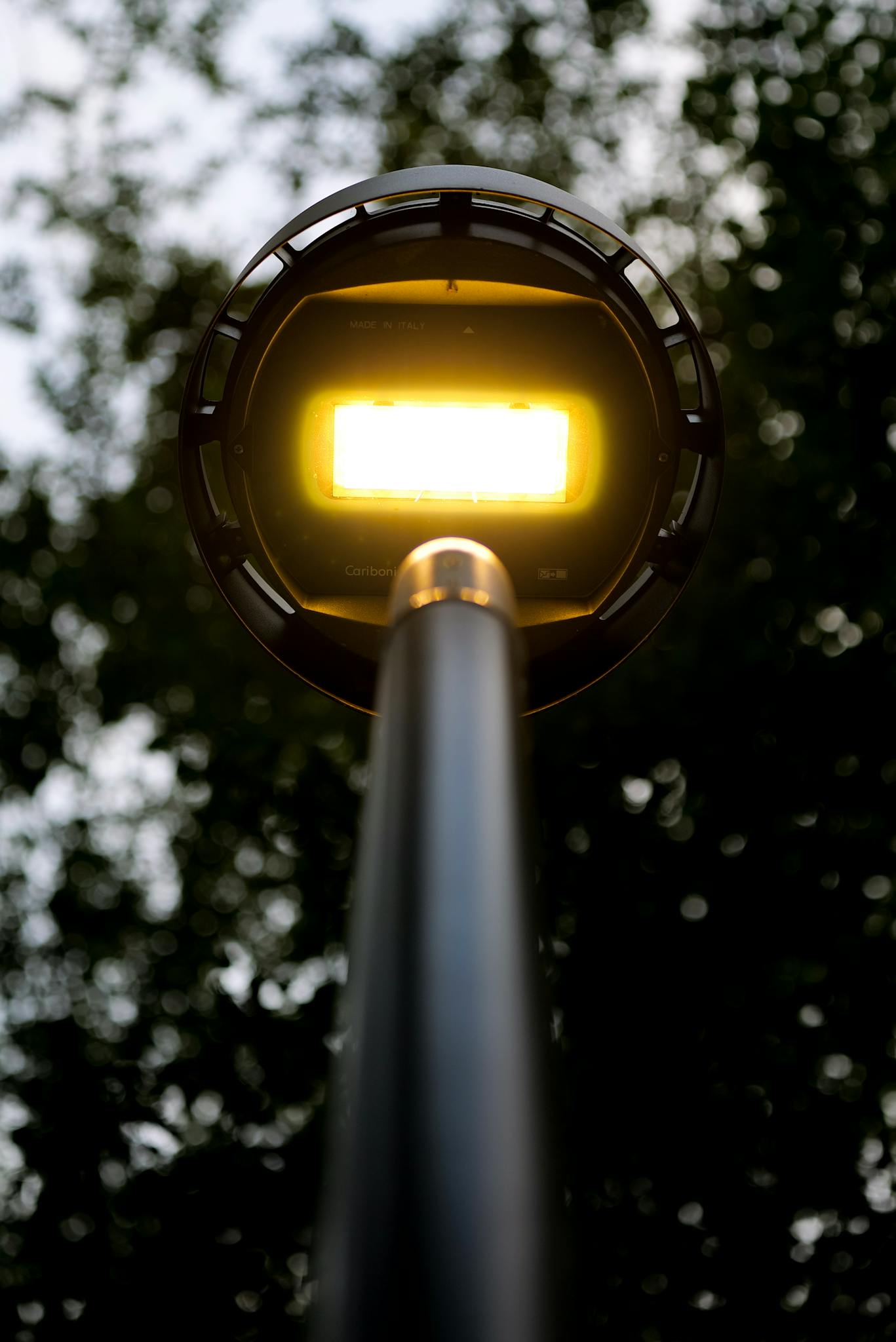 A modern street lamp glowing brightly against the evening sky in Velika, Croatia.