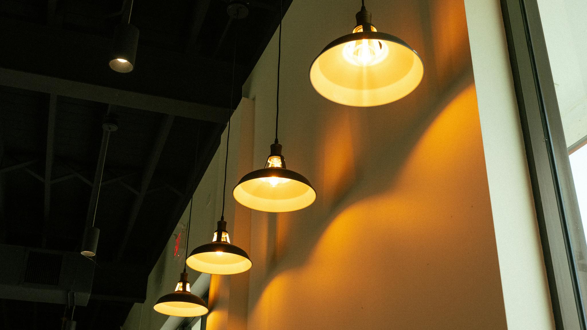 An array of pendant lamps casting a warm glow in a modern indoor setting.